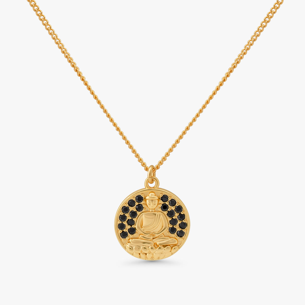 A gold pendant necklace featuring a circular medallion with a seated Buddha figure, accented by small black stones around the upper half, suspended from a delicate gold chain against a light gray background.