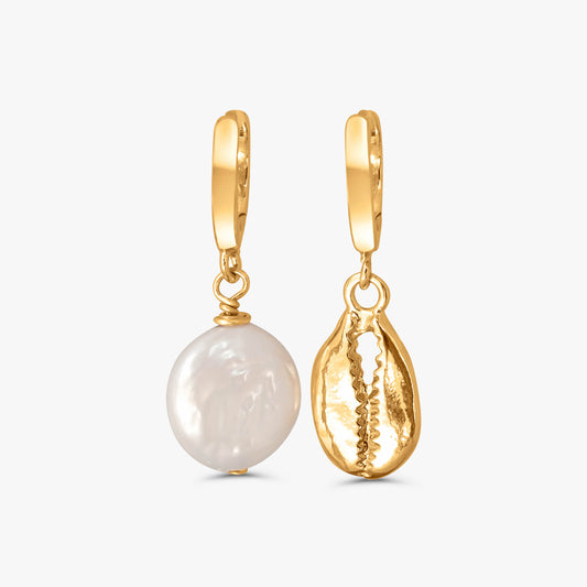 A pair of gold hoop earrings with dangling charms, one featuring a round white baroque pearl and the other a textured gold shell-shaped charm, shown on a light gray background.