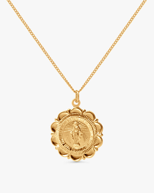 A gold chain necklace with a circular medallion pendant featuring a detailed religious figure, shown against a plain light gray background.