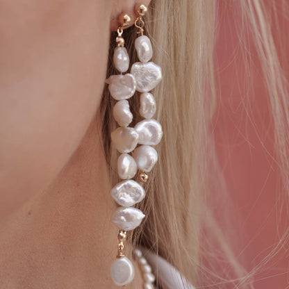 Close-up profile of a woman wearing long 14k Gold Filled stacked freshwater pearl drop earrings.
