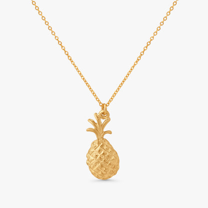 A gold pineapple pendant necklace on a delicate gold chain, presented against a clean, light gray background.