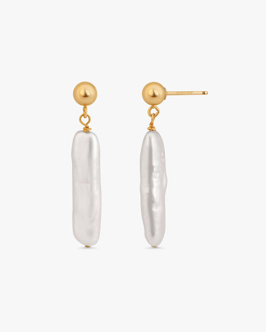 A pair of gold and baroque pearl drop earrings on a clean white background.