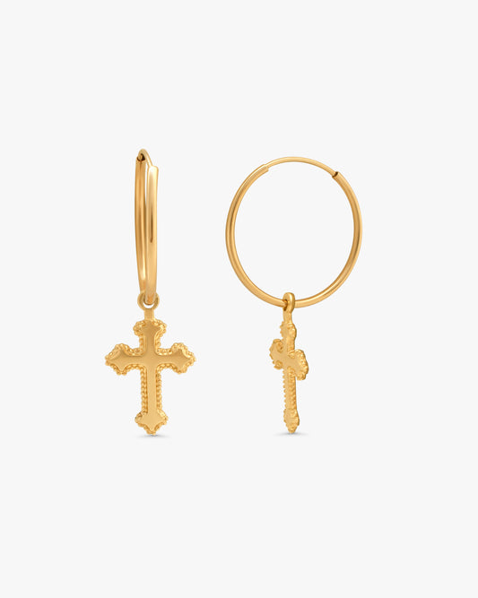 A pair of gold hoop earrings with dangling textured cross charms, displayed on a clean white background.