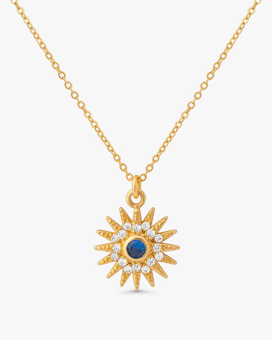 Sunniva Sun Ray & Starburst 14k gold filled necklace with blue sapphire and crystal sunburst pendant on white background