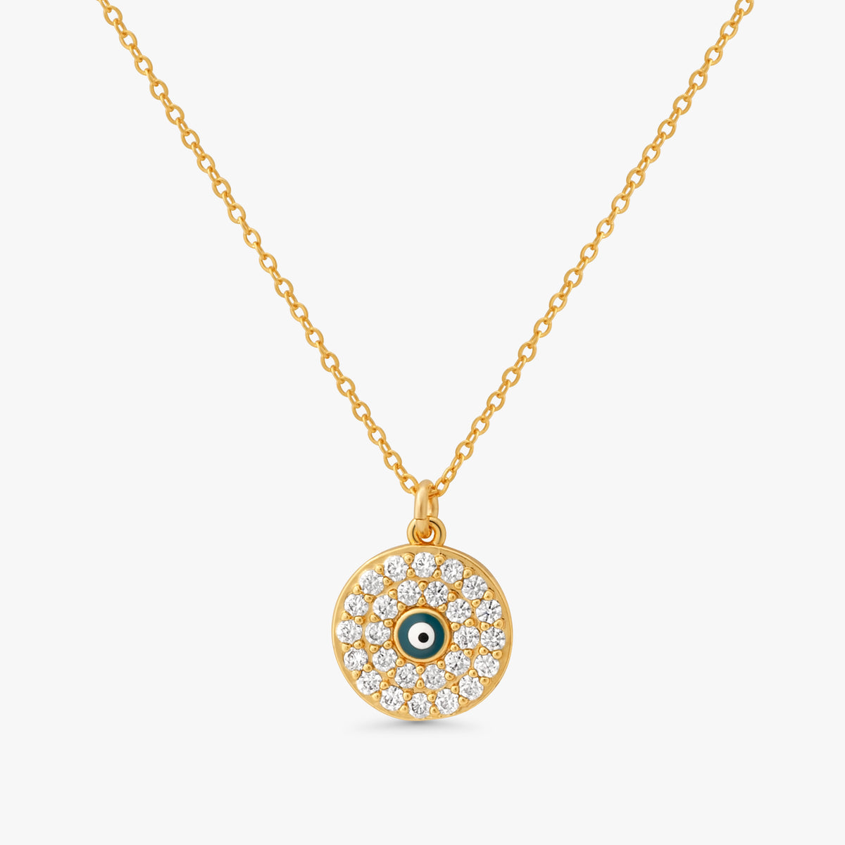A gold chain necklace with a circular evil eye pendant, featuring clear pavé stones and a small green and white eye detail in the center, set against a light gray background.