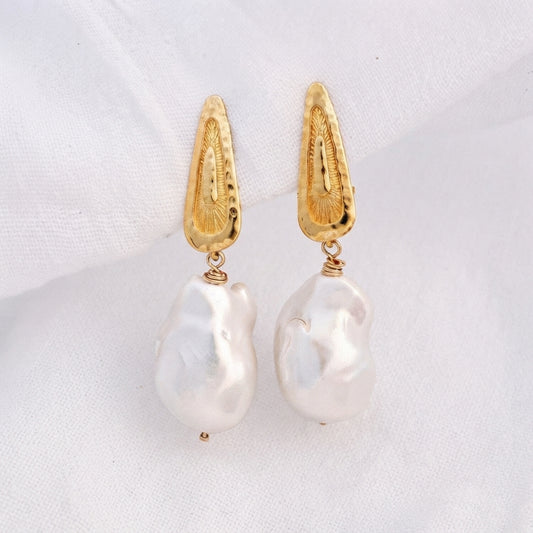 Pair of clip-on earrings featuring hammered 14K Gold Vermeil tops and hanging baroque pearls.