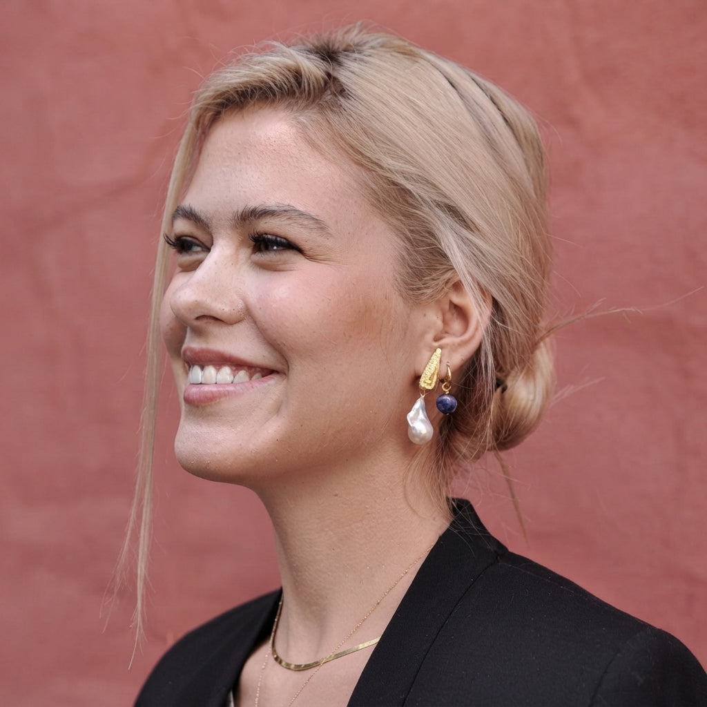 A blonde woman with an updo wearing an Elodie Baroque Pearl Clip-On Earring.