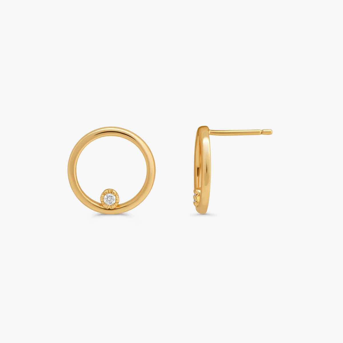 A pair of gold hoop earrings, one shown from the front with a small clear gemstone at the bottom and the other from the side showing the post and back, on a light gray background.