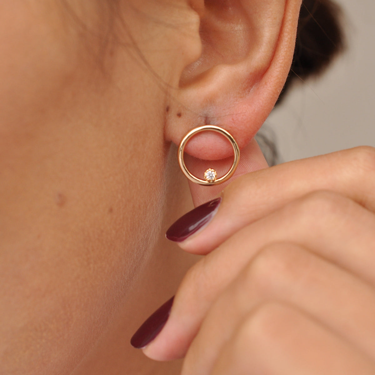 Woman wearing Ora Circle Solitaire 14k gold plated stud earring close-up