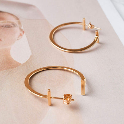 Avel Downtown Edge 14k gold plated geometric hoop earrings displayed flat on neutral surface
