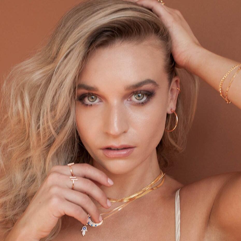 Blonde woman wearing Elara Moon 14k gold filled crescent necklace with hand near face