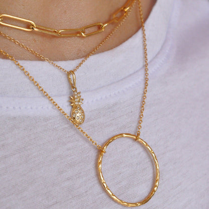 Close-up of Alba Pineapple 14k solid gold necklace layered with gold chain and circle pendant