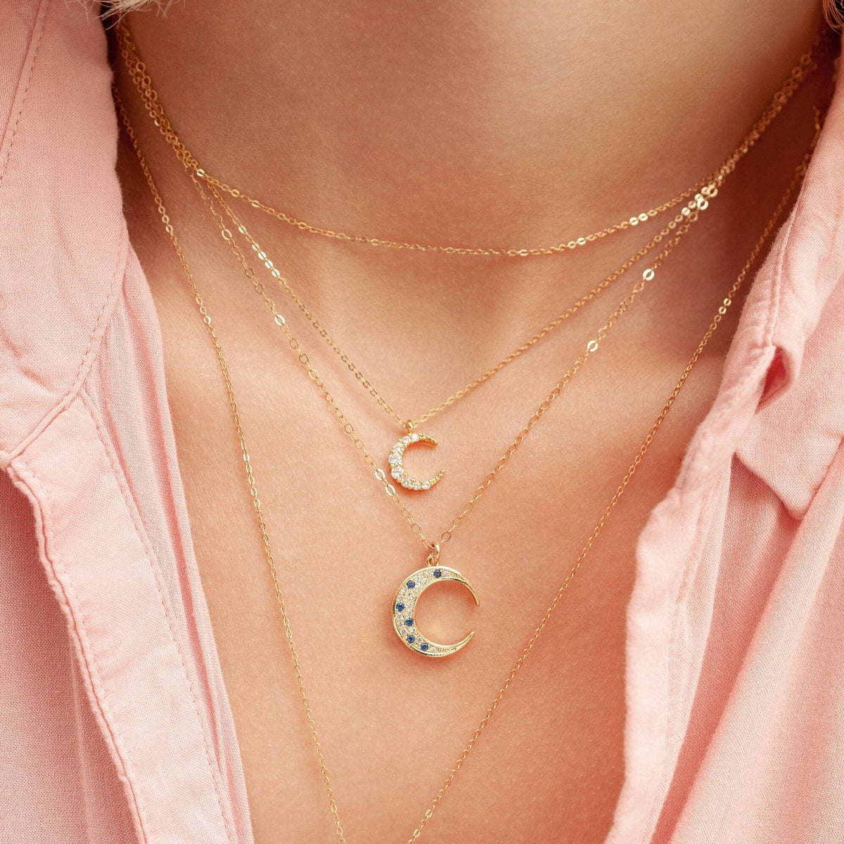 Close-up of Elara Moon 14k gold filled crescent necklace layered with dainty gold chains