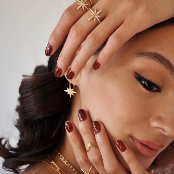 High-angle portrait of a woman looking upward while wearing 14k Gold Plated Sola Starburst Earrings.