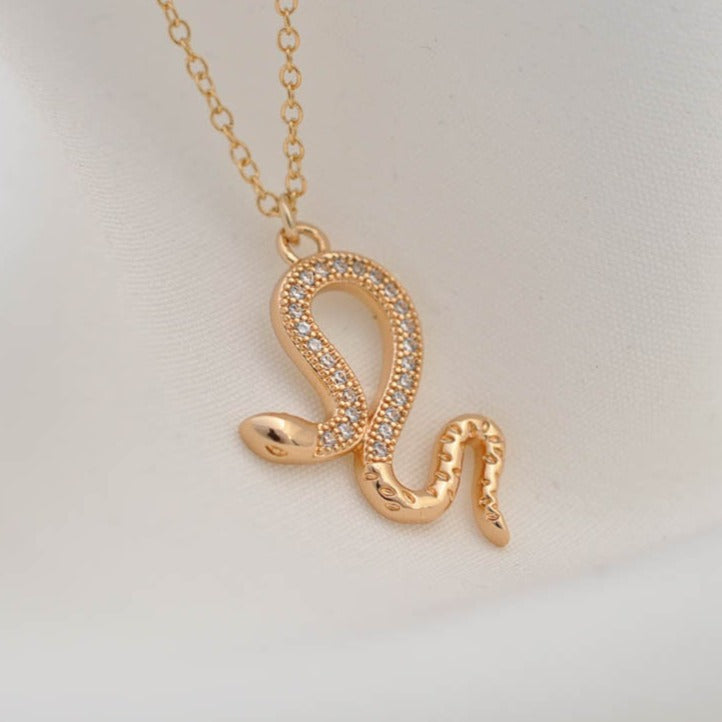 Jolie Snake 14k gold filled pendant necklace with crystal accents on white fabric