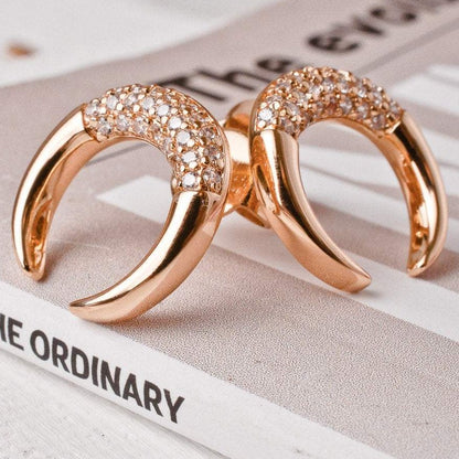 Pair of Bravi Double Horn 14k gold plated stud earrings displayed on book page