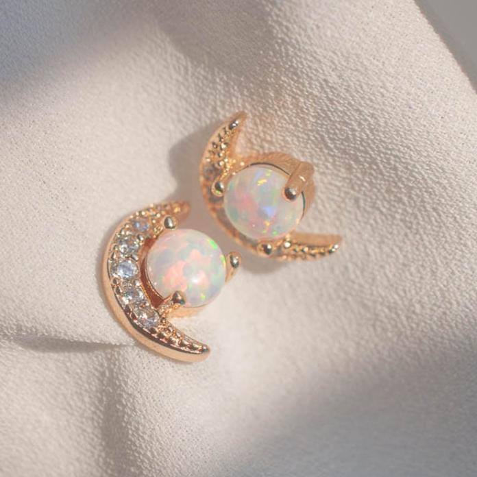Pair of women's 14k Gold Plated Tuva Opal Moon Studs displayed flat under natural sunlight and shadows.
