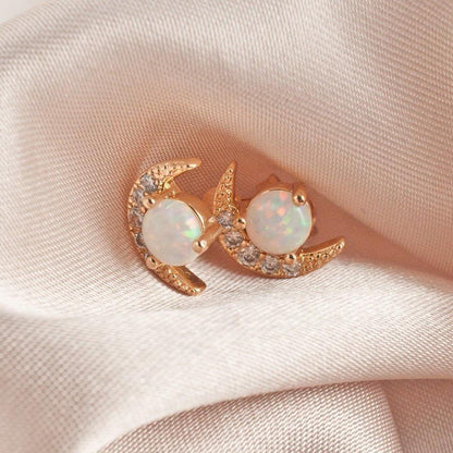 Pair of women's 14k Gold Plated Tuva Opal Moon Studs resting on soft white satin cloth.