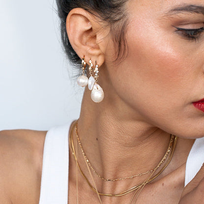 Profile view of woman wearing Dagny Flat Bar 14k gold filled chain with pearl drop earrings
