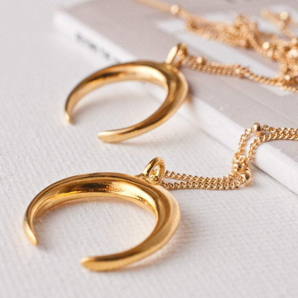 Ro Horn 14k gold filled crescent horn pendants on satellite and box chains displayed flat on white surface
