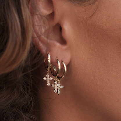 Side profile view of a woman wearing stacked 14k Gold Plated Solid Mini Cross Hoops.