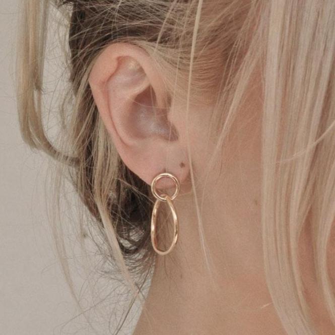 Side view of a woman with blonde hair wearing 14k gold plated Sena double circle stud hoop earrings