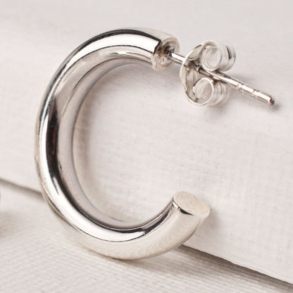 Single women's sterling silver chunky open hoop earring showing butterfly post back.