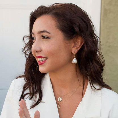 Smiling dark-haired woman wearing Alba Pineapple 14k solid gold necklace in white top