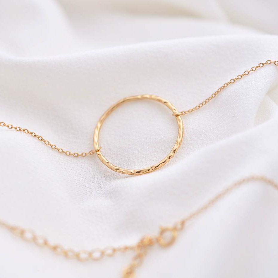 Sora Hammered Circle 14k gold vermeil necklace with textured ring charm displayed on white fabric