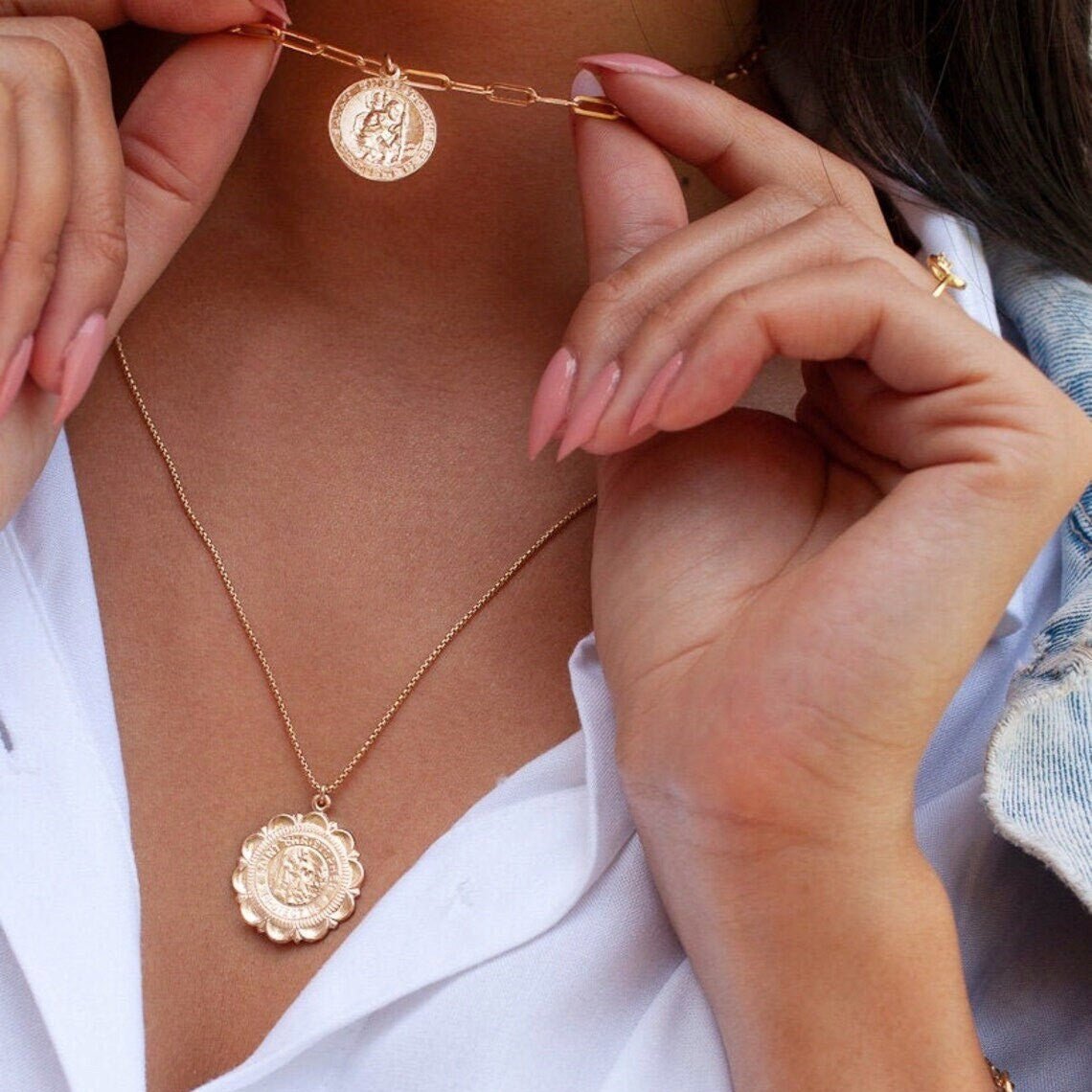 Woman holding Amora Mary 14k gold filled medallion pendant close to neck