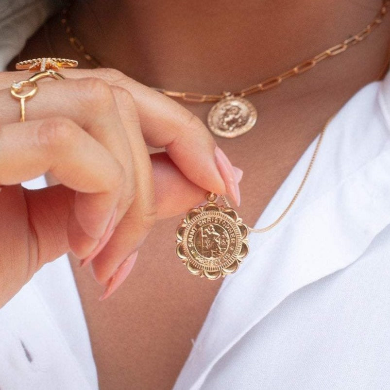Woman holding Viva Saint Christopher 14k gold filled scalloped medallion pendant in white top