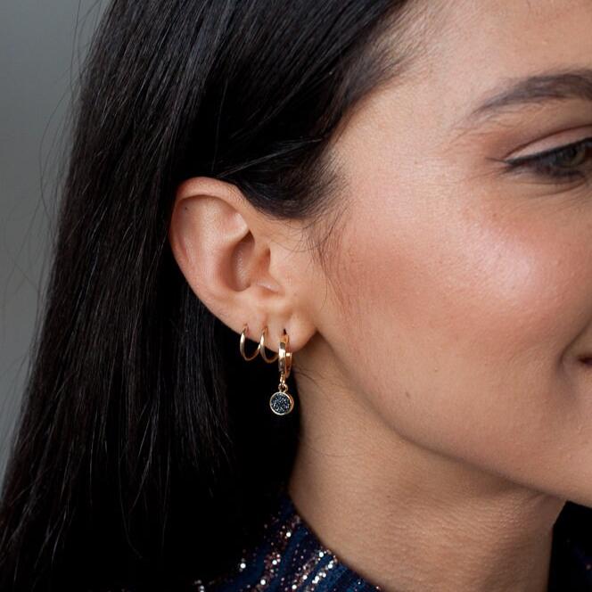 Woman wearing 14k gold filled Nia sleeper hoop earrings with charm pendants