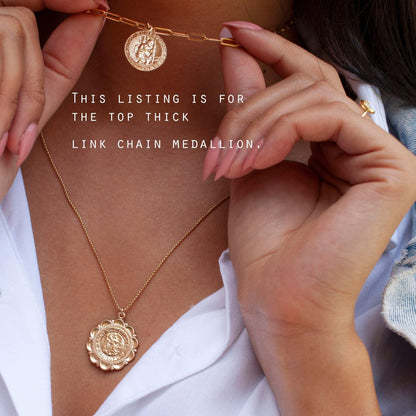 Woman wearing Auri Saint Christopher 14k gold filled paperclip necklace holding coin medallion pendant