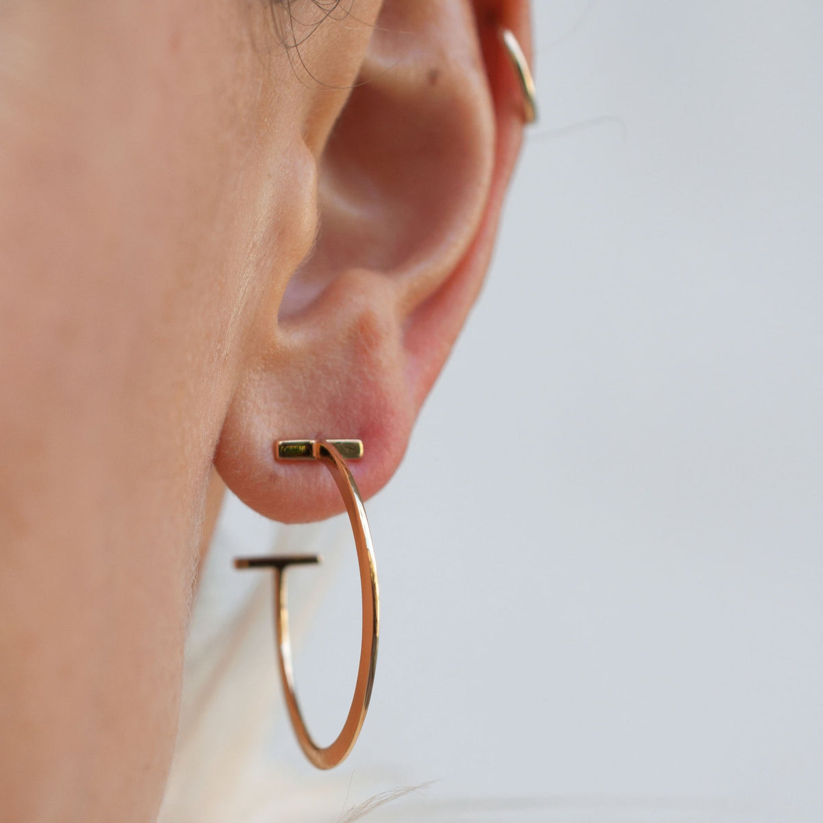 Woman wearing Avel Downtown Edge 14k gold plated hoop earring side view