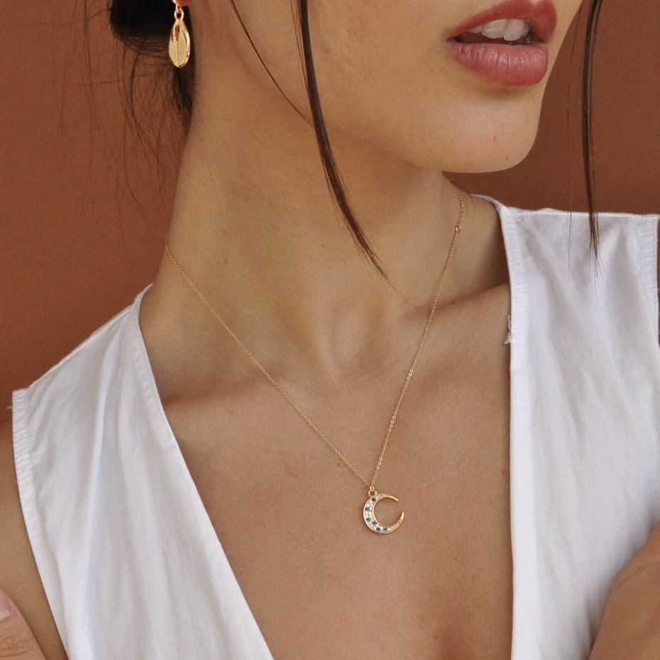 Woman wearing Elara Moon 14k gold filled crescent necklace in white unbuttoned shirt