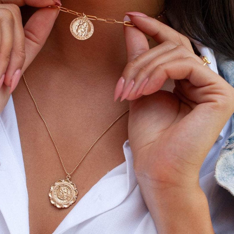Woman wearing Viva Saint Christopher 14k gold filled scalloped medallion necklace with hands adjusting chain