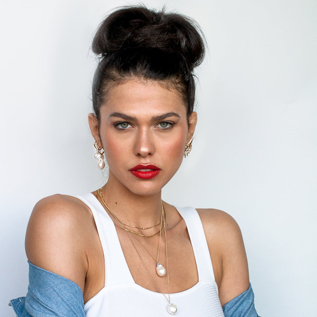 Woman with hair in a high bun wearing Dagny Flat Bar 14k gold filled layering necklace with denim jacket