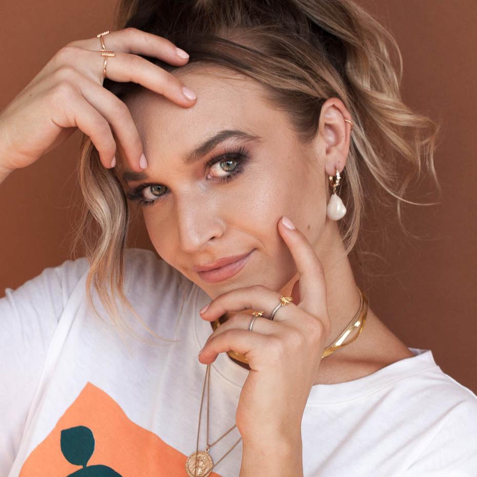 Woman with hand in hair wearing 14k gold filled Amia baroque pearl drop earrings