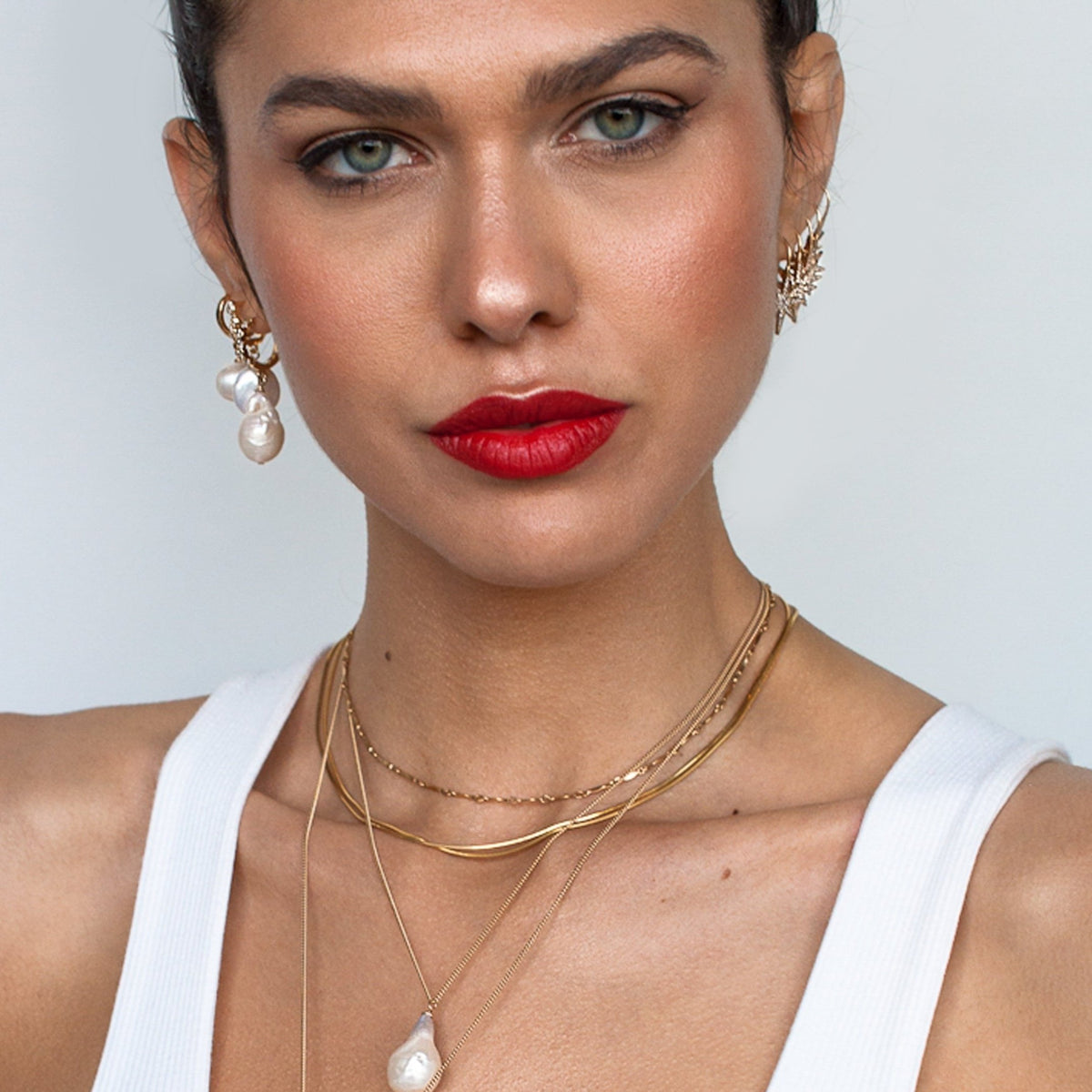 Woman with red lipstick wearing Dagny Flat Bar 14k gold filled layering necklace in white tank top