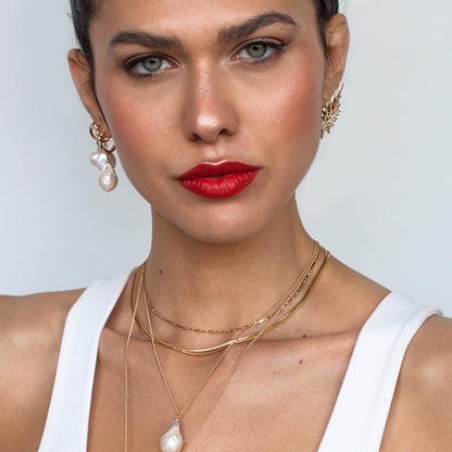 Woman with red lipstick wearing Dagny Flat Bar 14k gold filled layering necklace in white tank top